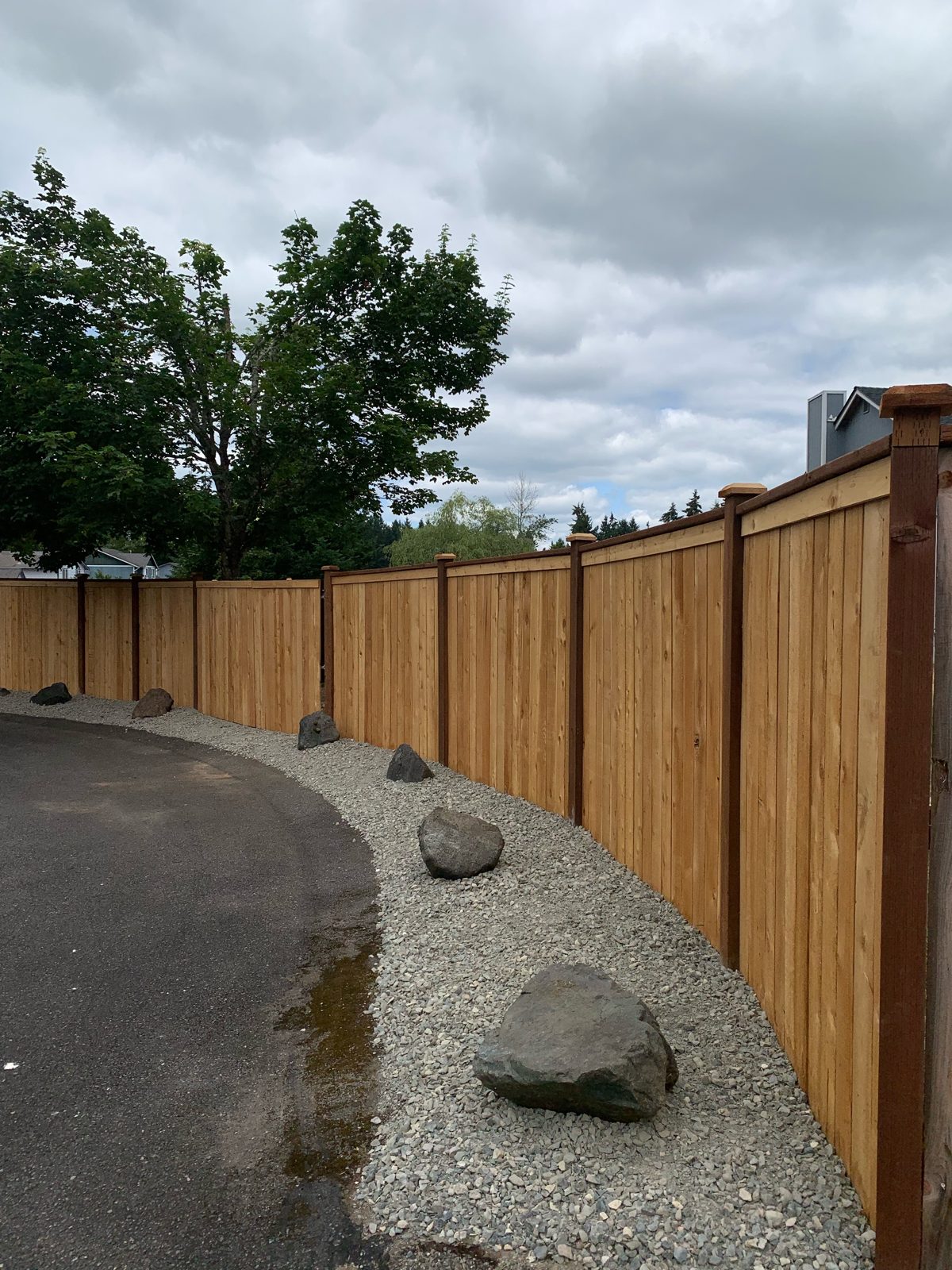 Cedar fence along a curved driveway